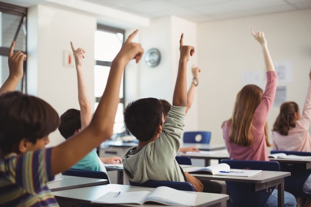 Ninos Escuela Levantando Mano Aula